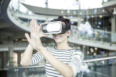 Entwickler gestikuliert mit Virtual-Reality-Headset in der Roboterwerkstatt - WESTF24802