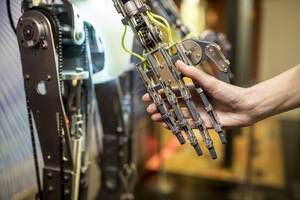 Ingenieur beim Händeschütteln mit Roboterarm in der Werkstatt - WESTF24805