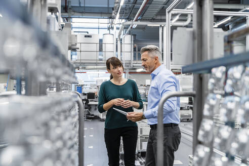 Geschäftsmann im Gespräch mit einem Kollegen in einer Fabrik - DIGF17061