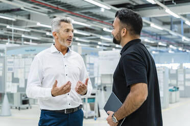 Geschäftsmann im Gespräch mit einem Ingenieur in einer Fabrik - DIGF17179