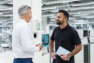 Geschäftsmann im Gespräch mit lächelndem Ingenieur in der Industrie - DIGF17180