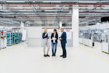 Businesswoman having discussion with colleagues at automated factory - DIGF17206