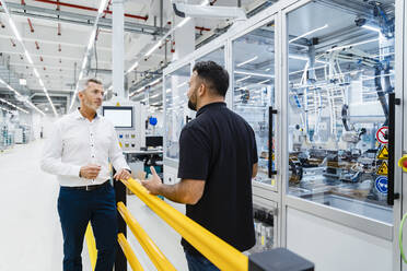 Businessman having discussion with engineer at industrial machinery - DIGF17226