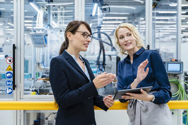 Geschäftsfrauen mit Tablet-PC im Gespräch in der automatisierten Industrie - DIGF17236