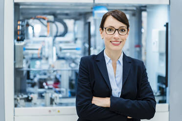 Businesswoman with arms crossed at electrical industry - DIGF17300