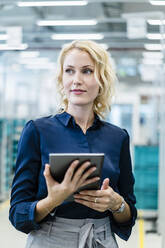 Blonde Geschäftsfrau mit Tablet-PC in der Industrie - DIGF17306