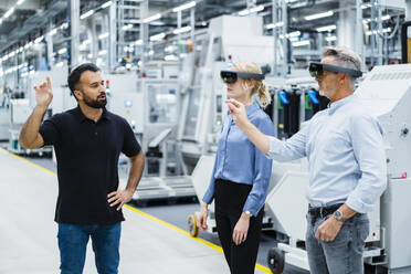 Coworkers with augmented reality glasses working at industry - DIGF17331