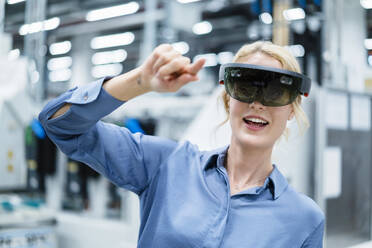 Geschäftsfrau mit Augmented-Reality-Brille in der Industrie - DIGF17335