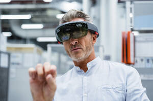 Geschäftsmann mit Augmented-Reality-Brille in der Fabrik - DIGF17344