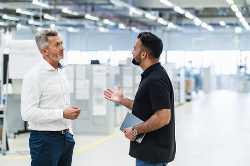 Geschäftsmann im Gespräch mit Ingenieur in automatisierter Industrie - DIGF17363