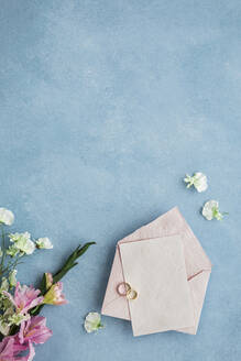Studioaufnahme eines Paares von Eheringen, einer Einladungskarte und eines Blumenstraußes - FLMF00734