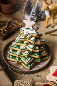 Christmas cookie tree with falling powdered sugar on table - FLMF00759