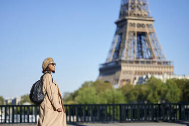 Junge Frau im Trenchcoat vor dem Eiffelturm, Paris, Frankreich - KIJF04357