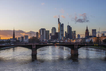 Germany, Hesse, Frankfurt, Ignatz Bubis Bridge at dusk with downtown skyline in background - RUEF03437