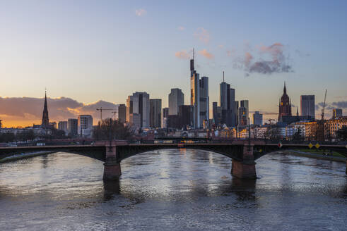 Deutschland, Hessen, Frankfurt, Ignatz-Bubis-Brücke in der Abenddämmerung mit Skyline der Innenstadt im Hintergrund - RUEF03437