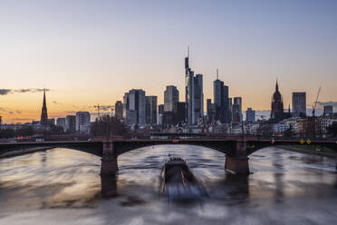 Deutschland, Hessen, Frankfurt, Ignatz-Bubis-Brücke in der Abenddämmerung mit Skyline der Innenstadt im Hintergrund - RUEF03438