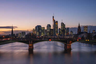 Germany, Hesse, Frankfurt, Ignatz Bubis Bridge at dusk with downtown skyline in background - RUEF03439