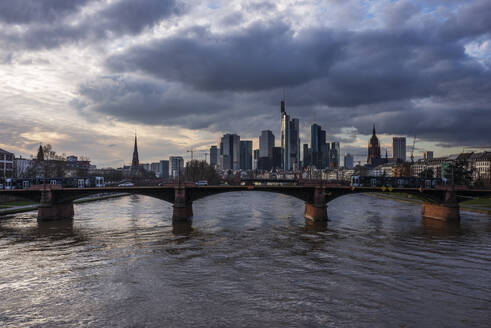 Deutschland, Hessen, Frankfurt, Bewölkter Himmel über der Ignatz-Bubis-Brücke in der Abenddämmerung mit der Skyline der Innenstadt im Hintergrund - RUEF03443