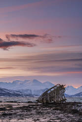 Rainbow and beached old wooden fishing boats on shore at Salen Stock Photo  by Mint_Images