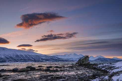 Schiffswrack am Ufer eines abgelegenen Fjords in der Winterdämmerung - RUEF03447