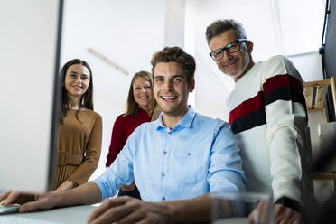 Glückliche Mitarbeiter bei der Zusammenarbeit im Büro - GIOF14543