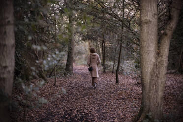 Junge Frau beim Spaziergang im Herbstwald - CAIF31814