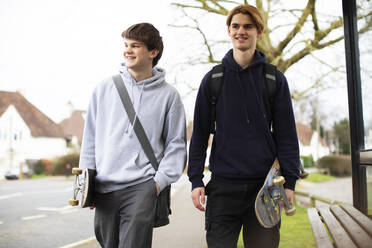 Fröhliche Teenager mit Skateboards auf dem Bürgersteig - CAIF31875
