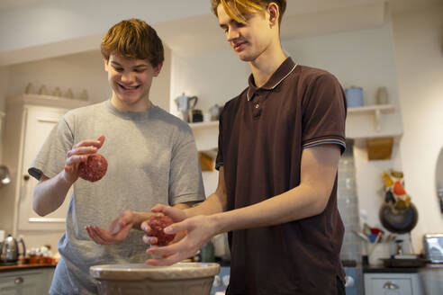 Teenager-Jungen machen Hamburger in der Küche - CAIF31877