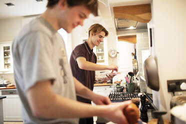Teenager-Jungen kochen zu Hause in der Küche - CAIF31879