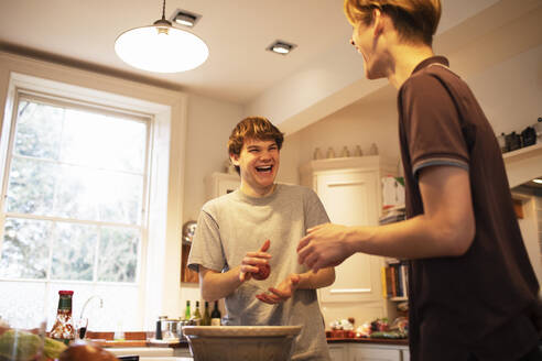 Fröhliche Teenager-Jungs machen Hamburger-Patties in der Küche - CAIF31881