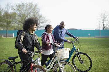 Family with bicycles in park grass - CAIF31926