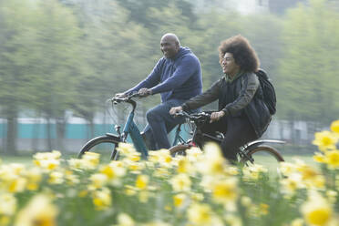 Glücklicher Vater und Sohn beim Fahrradfahren im Frühlingspark - CAIF31939