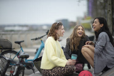 Happy young women friends laughing in city - CAIF31966