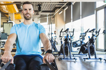 Sportler bei der Benutzung von Fitnessgeräten im Fitnessstudio - IFRF01285