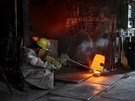 Handwerker in Arbeitsschutzkleidung beim Gießen von Metallguss im Stahlwerk - CVF01764