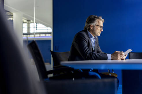 Businessman using tablet PC at workplace - PESF03355