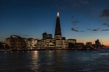 Beleuchtete moderne Gebäude an der Themse in der Stadt in der Abenddämmerung, London, England, UK - MRRF01797