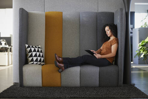 Geschäftsfrau bei der Arbeit mit einem Tablet-PC auf dem Sofa am Arbeitsplatz - RBF08507