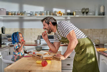 Vater und Tochter essen an der Kücheninsel - CAIF31980