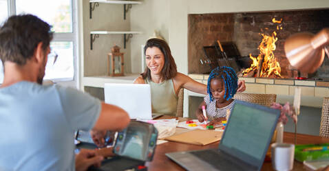 Familie arbeitet und malt am Esstisch - CAIF32012