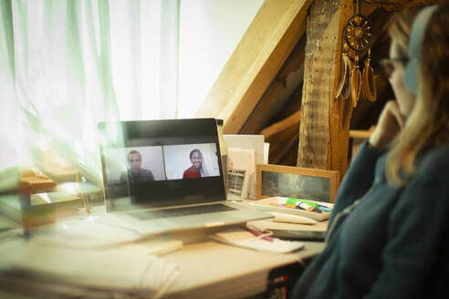 Woman video conferencing with colleagues on laptop screen - CAIF32049