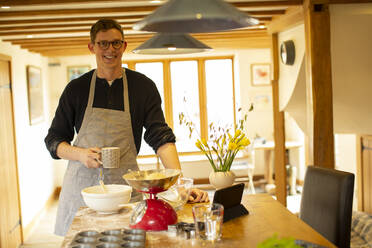 Porträt lächelnder Mann beim Backen in der Küche - CAIF32101