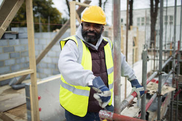 Porträt eines selbstbewussten männlichen Bauarbeiters auf einer Baustelle - CAIF32119
