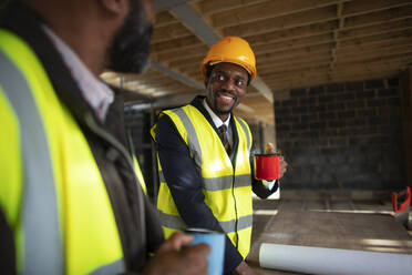 Männliche Architekten trinken Kaffee auf der Baustelle - CAIF32134