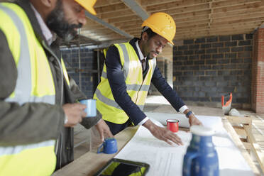 Ingenieur und Architekt bei der Überprüfung von Bauplänen auf der Baustelle - CAIF32141