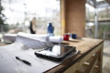 Digitales Tablet und Baupläne auf der Baustelle - CAIF32163