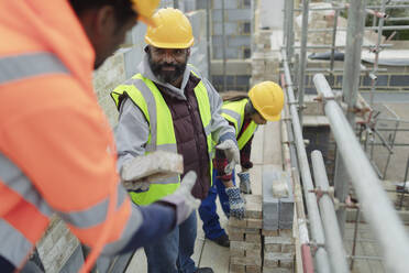 Bauarbeiter beim Verlegen von Ziegeln auf einer Baustelle - CAIF32173