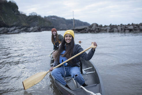 Portrait happy young couple canoeing on river - CAIF32191