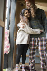 Glückliches junges Paar im Pyjama, das sich umarmt - CAIF32195