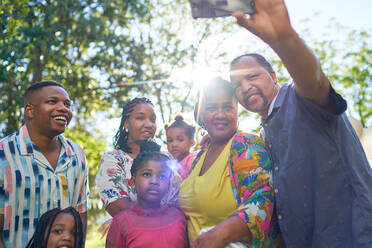 Glückliche Mehrgenerationenfamilie macht Selfie im sonnigen Park - CAIF32254